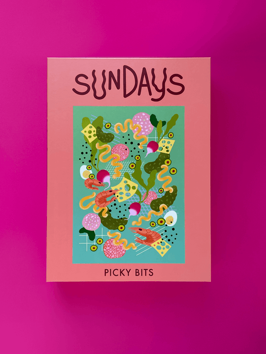 EIne altrosa Box mit dem Aufdruck Sundays und dem Motiv des Puzzles Picky Bits auf pinkem Hintergrund
