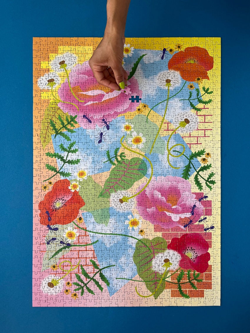 A puzzle with one missing piece lies on blue background, a hand with a single piece comes into the frame to place the final piece